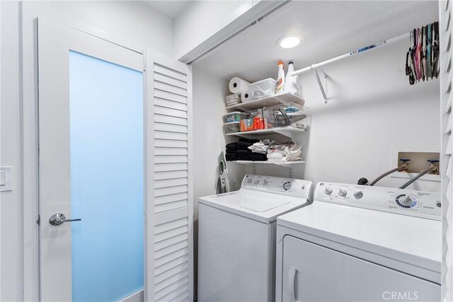 clothes washing area with washer and clothes dryer