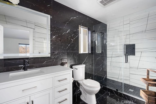 bathroom featuring toilet, vanity, tile walls, and an enclosed shower