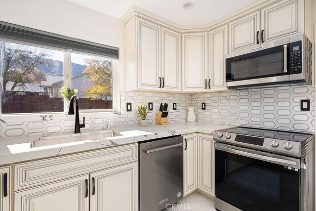 6124 Juniper Rd, Lake Isabella, CA 93240 - kitchen featuring stainless steel appliances, cream cabinets, decorative backsplash, and light stone counters