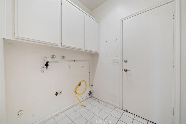 laundry room featuring cabinets, light tile patterned flooring, and gas dryer hookup