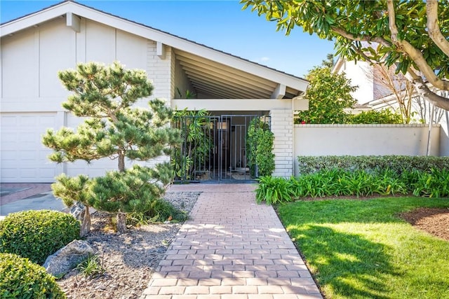 entrance to property featuring a garage and a yard