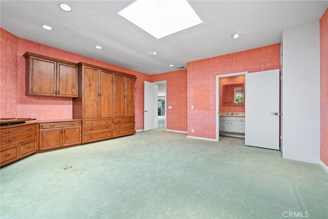 interior space featuring light colored carpet and a skylight