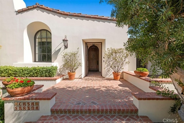 view of exterior entry featuring a patio