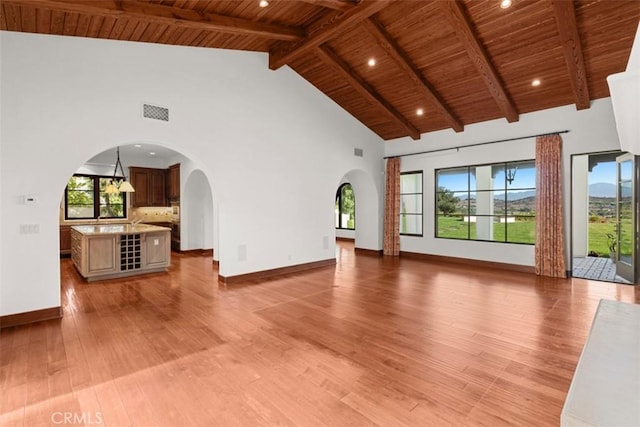 unfurnished living room with high vaulted ceiling, plenty of natural light, and wood ceiling