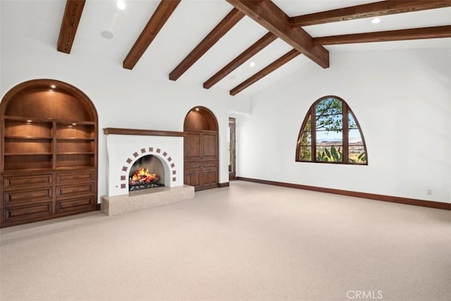 unfurnished living room featuring carpet, beam ceiling, high vaulted ceiling, and built in shelves