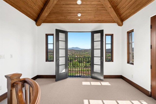 interior space featuring light colored carpet, wood ceiling, and a mountain view