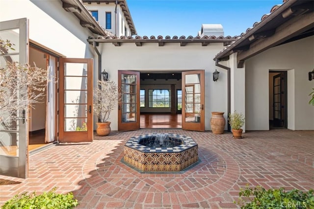 view of exterior entry with a patio area