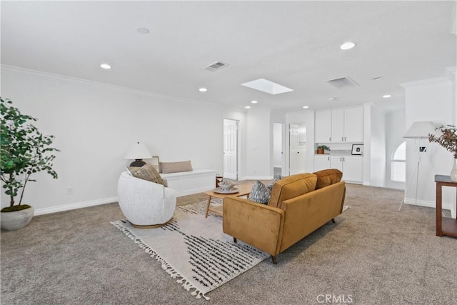 carpeted living room featuring a skylight and ornamental molding