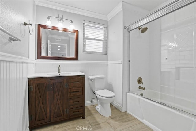 full bathroom featuring toilet, bath / shower combo with glass door, ornamental molding, and vanity