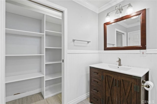 bathroom featuring wood-type flooring, vanity, and ornamental molding