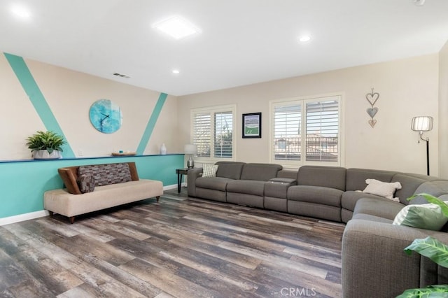 living room with recessed lighting, visible vents, baseboards, and wood finished floors