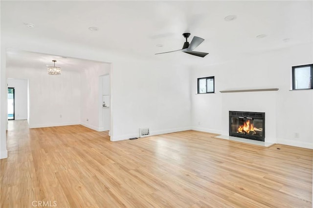 unfurnished living room featuring ceiling fan and light hardwood / wood-style floors