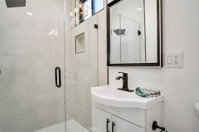 bathroom with a shower with shower door and vanity