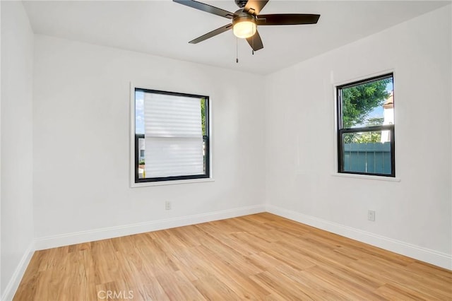 empty room with ceiling fan and light hardwood / wood-style floors