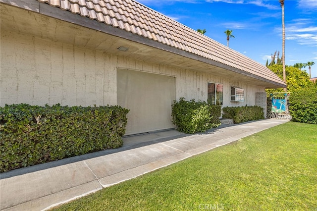 view of exterior entry featuring a lawn