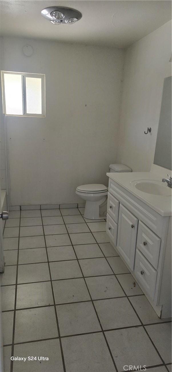 bathroom featuring toilet, vanity, and tile patterned flooring