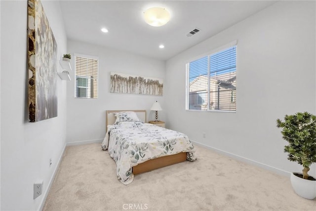 bedroom featuring light colored carpet and multiple windows