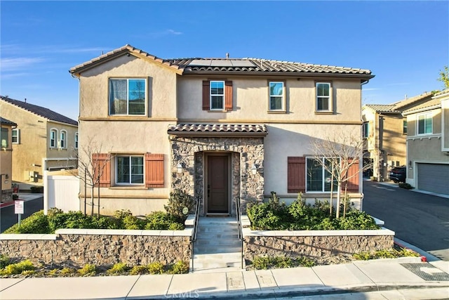 mediterranean / spanish-style house featuring solar panels