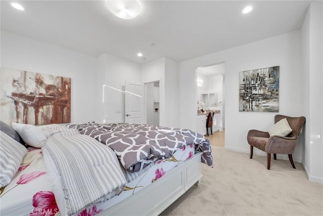 bedroom featuring ensuite bath and light colored carpet