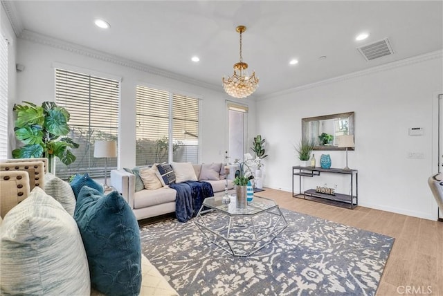 living room featuring ornamental molding, a notable chandelier, and light wood-type flooring