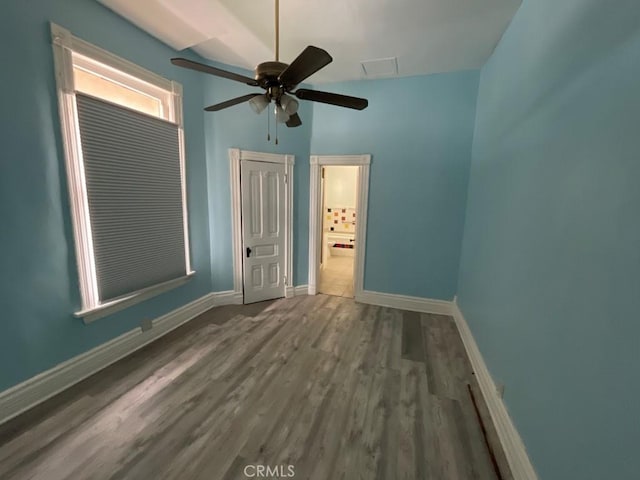 unfurnished bedroom with ceiling fan, a closet, and hardwood / wood-style flooring