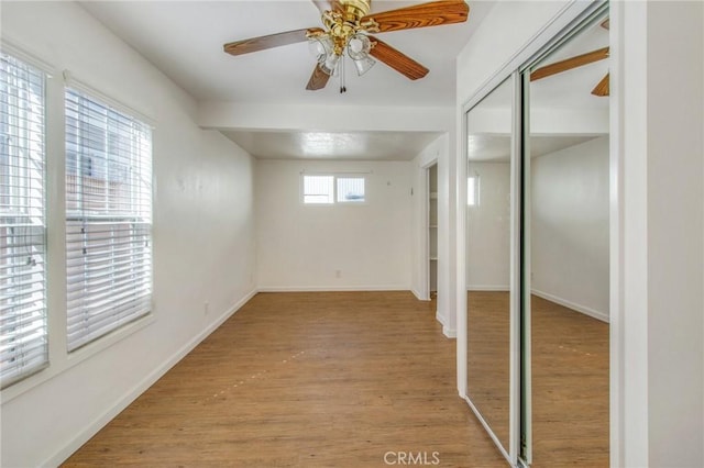 basement with ceiling fan and light hardwood / wood-style flooring