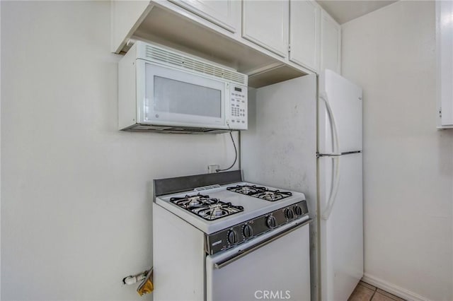 kitchen featuring light tile patterned floors, white appliances, and white cabinetry