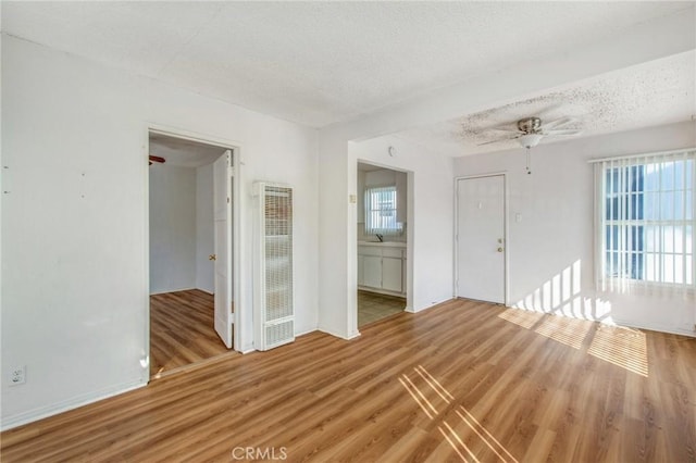 spare room featuring ceiling fan, sink, wood-type flooring, and a textured ceiling