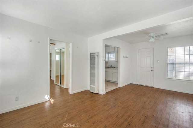 unfurnished room featuring ceiling fan, sink, and hardwood / wood-style floors