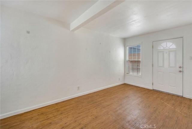 foyer entrance featuring beamed ceiling and hardwood / wood-style floors