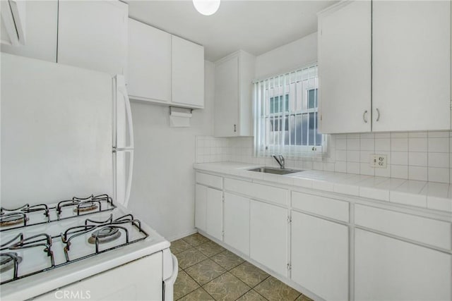 kitchen featuring tasteful backsplash, sink, white appliances, and white cabinetry