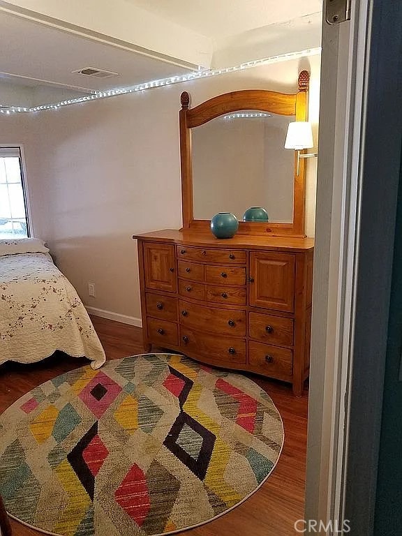 bedroom with dark hardwood / wood-style flooring