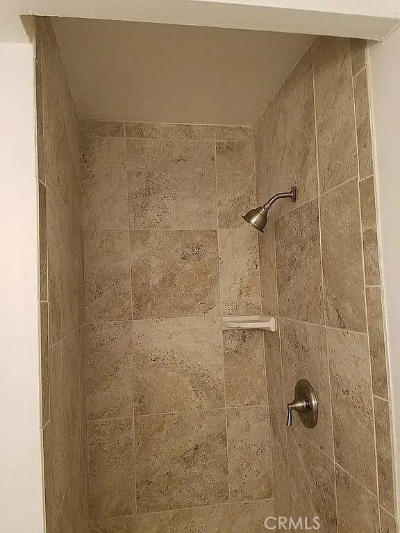 interior details with a tile shower