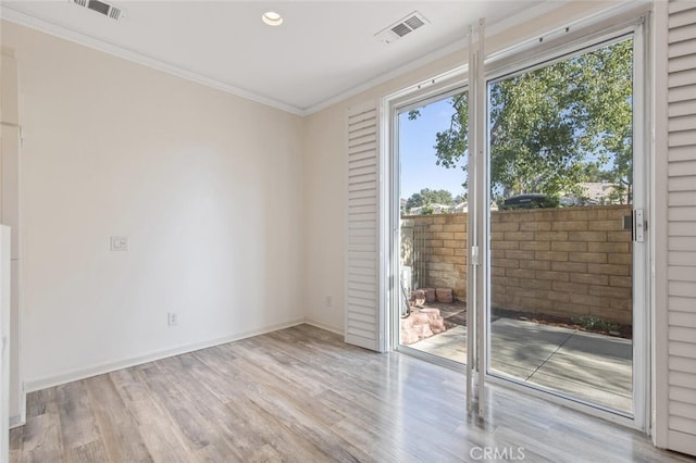 empty room featuring ornamental molding and light hardwood / wood-style floors