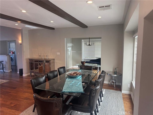 dining room featuring washer / dryer, a chandelier, dark hardwood / wood-style floors, and beamed ceiling