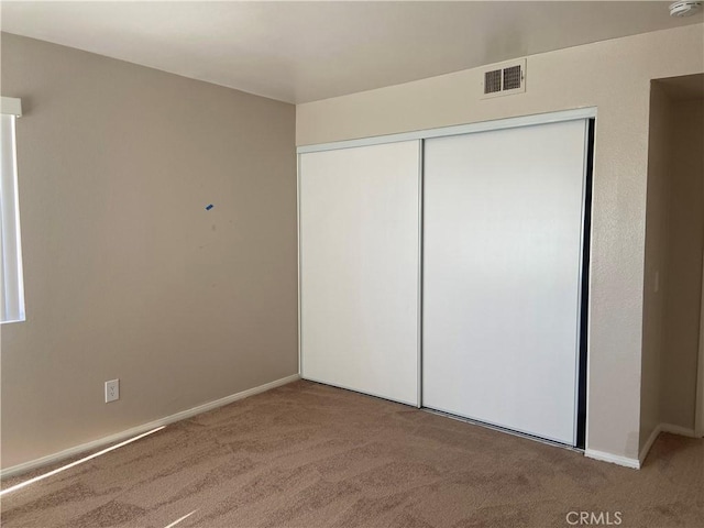 unfurnished bedroom featuring a closet and carpet floors