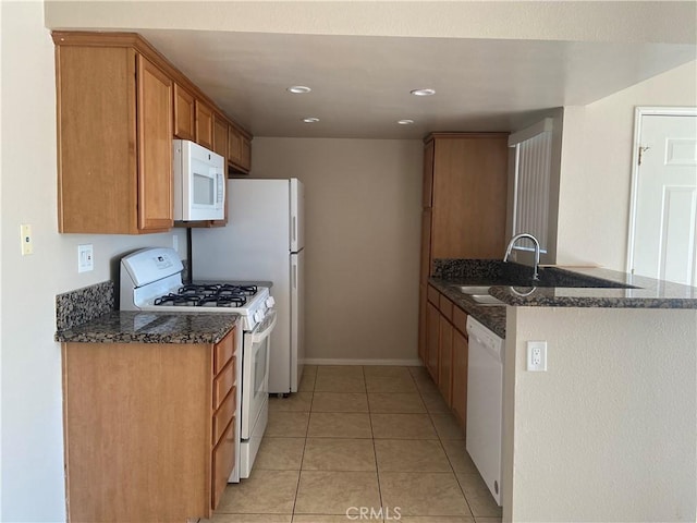 kitchen featuring kitchen peninsula, sink, white appliances, light tile patterned floors, and dark stone counters