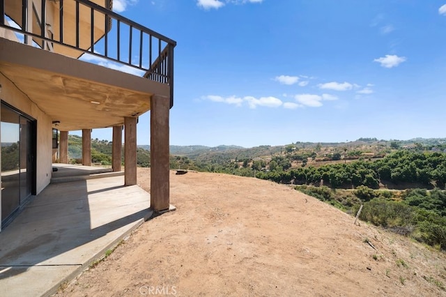 view of yard featuring a balcony and a patio