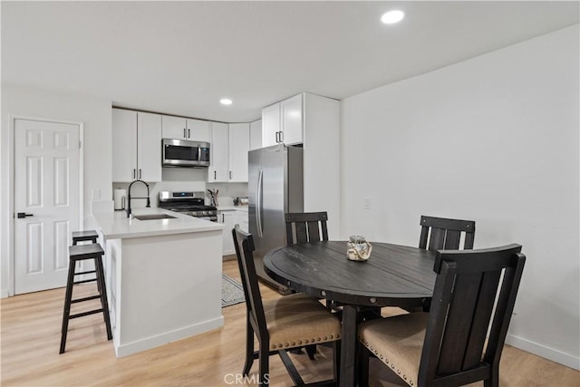 dining space with light hardwood / wood-style floors and sink