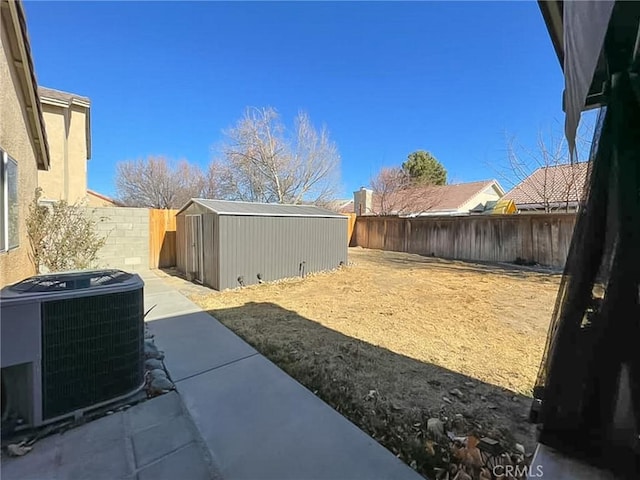 view of yard with central air condition unit, a storage shed, a fenced backyard, and an outdoor structure