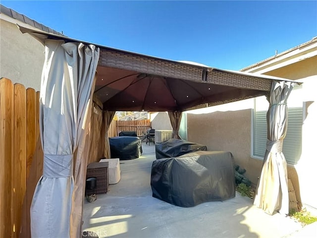 view of parking / parking lot featuring a gazebo and fence