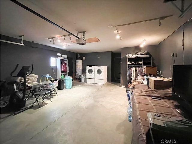 garage with a garage door opener, washer and dryer, and secured water heater