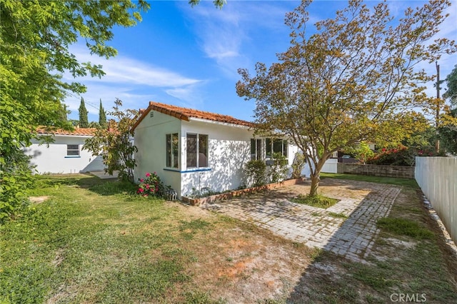 rear view of property featuring a patio area and a lawn