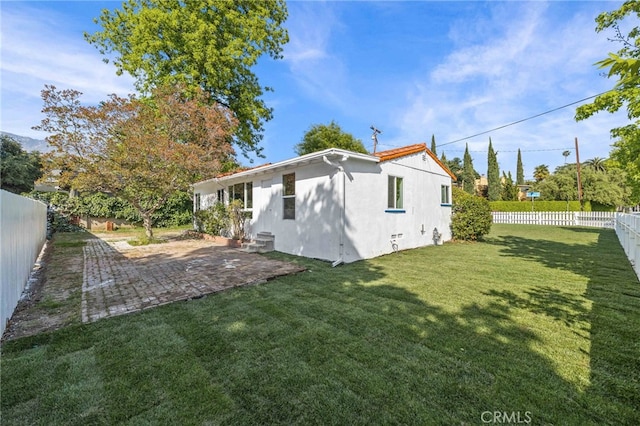 back of property with a patio area and a lawn