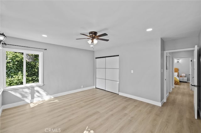 empty room with ceiling fan and light wood-type flooring