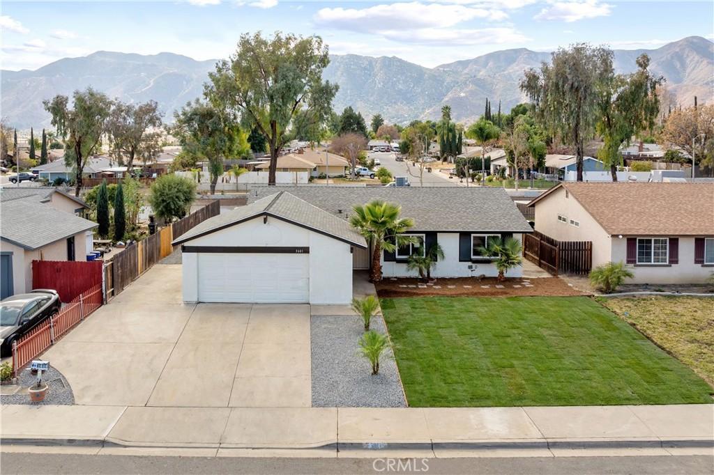 ranch-style house with a mountain view, a front yard, and a garage