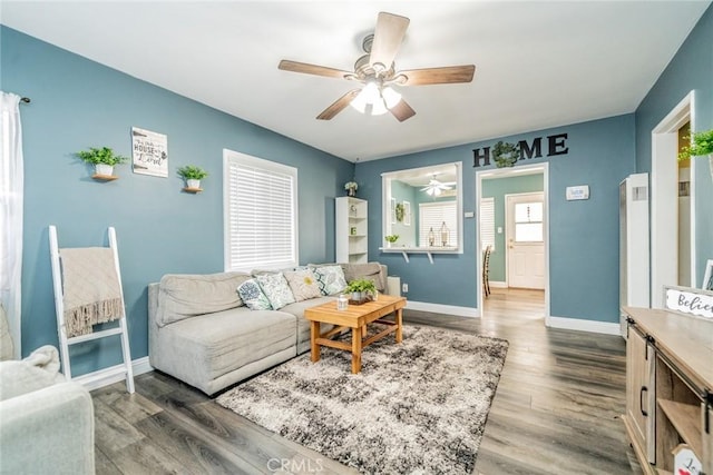 living room with dark hardwood / wood-style flooring and ceiling fan