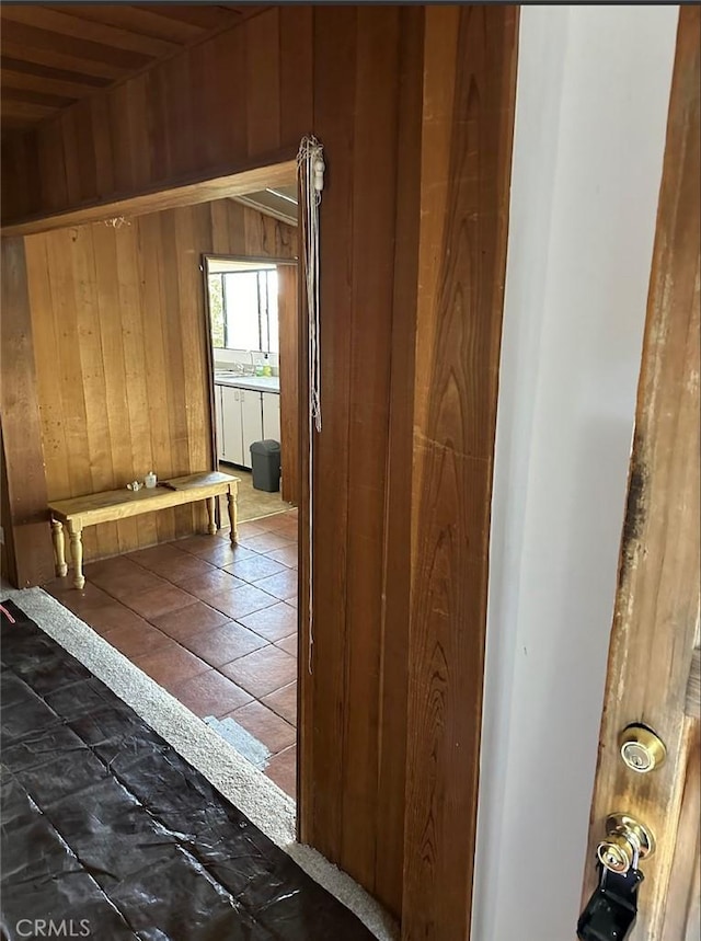 corridor featuring sink and wooden walls