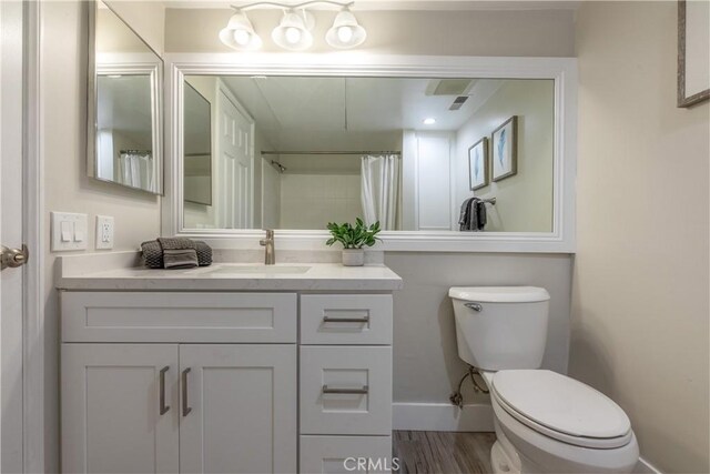 bathroom with vanity, toilet, hardwood / wood-style floors, and a shower with shower curtain