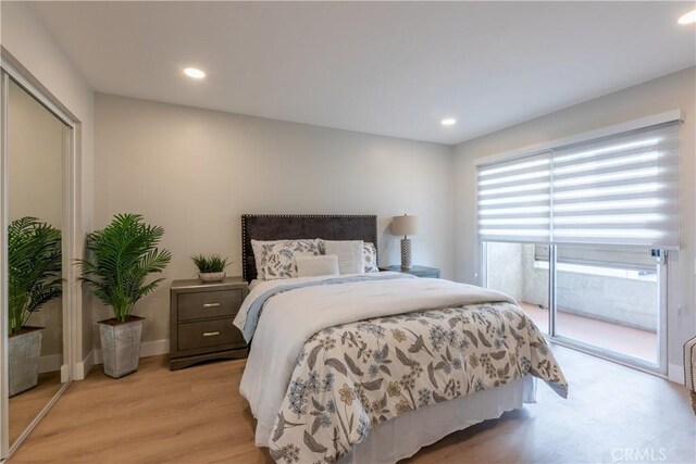 bedroom featuring light hardwood / wood-style floors, access to exterior, and a closet